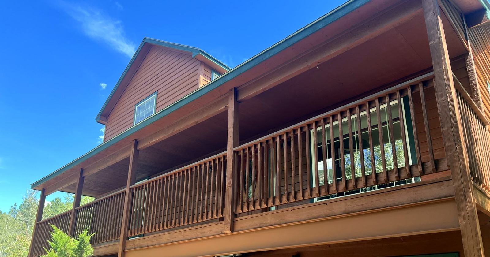 Two-story home with stained wraparound deck