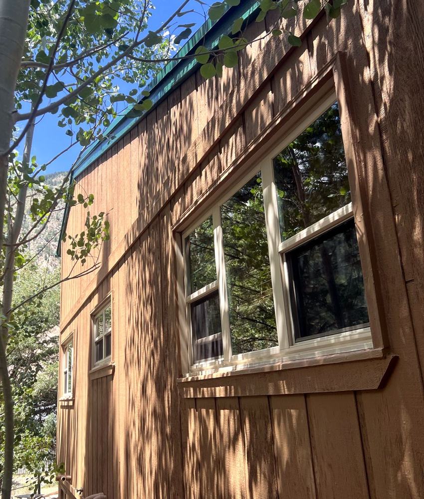 Tan siding and cream window trim